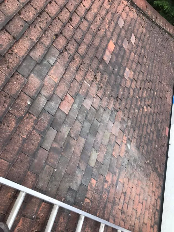 A red brick roof with a metal hand rail.