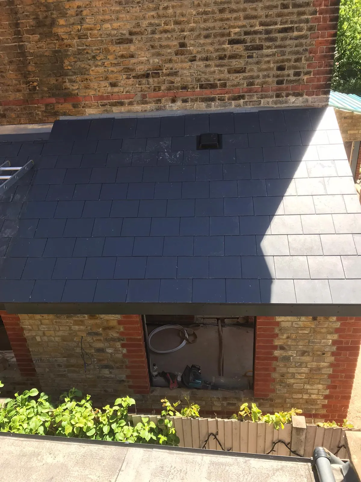 A building with a black roof and a brick wall.